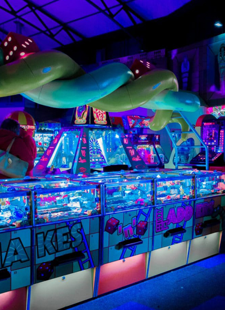 Salle d’arcades rétro avec jeux d’adresse et machines à prix dans un centre d’amusement éclairé