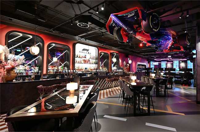 Espace bar lounge rétro avec ambiance arcade et tables conviviales dans un centre d’amusement