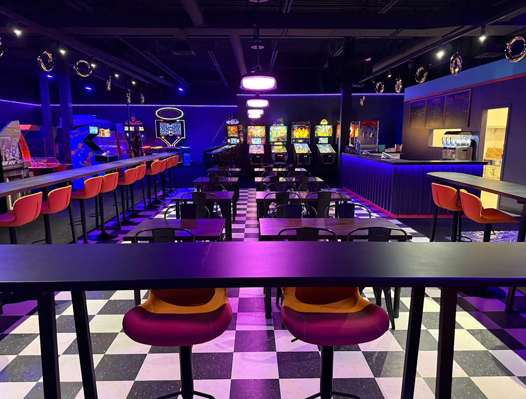 Personnes jouant au mini-golf intérieur fluorescent dans un décor immersif sous-marin